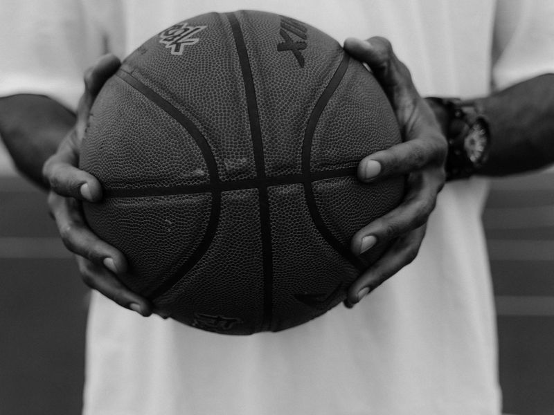 A focused man in athletic wear in a dimly lit, minimalist training space.
